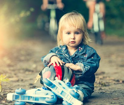 little girl on roller skates with helmet in the park