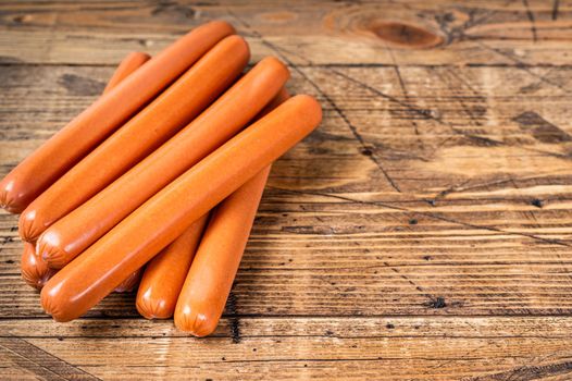 Raw frankfurter sausages on kitchen table. Wooden background. Top view. Copy space.