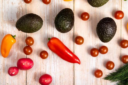 Assorted vegetables lying on a wooden table.