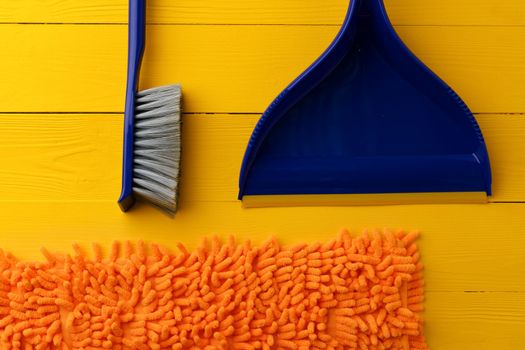 Household cleaning brush on yellow wooden background, top view