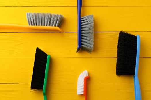 Cleaning tools composition flat lay on yellow wooden background, top view