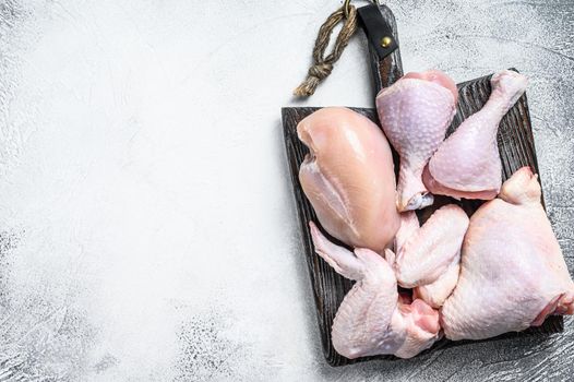 Fresh raw chicken meat, wings, breast, thigh and drumsticks. White background. Top view. Copy space.