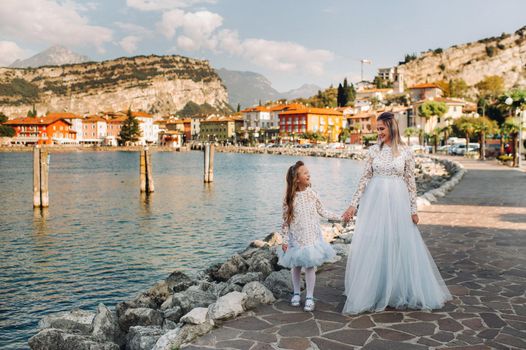 Italy, Lake Garda.Stylish Mother and daughter on the shores of lake Garda in Italy at the foot of the Alps. mother and daughter in Italy.