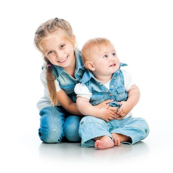 two cute sisters in the same clothes in studio isolated on white background