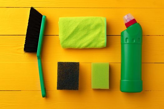 Cleaning tools composition flat lay on yellow wooden background, top view