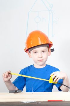 the boy makes measurements for building a birdhouse, labor lessons
