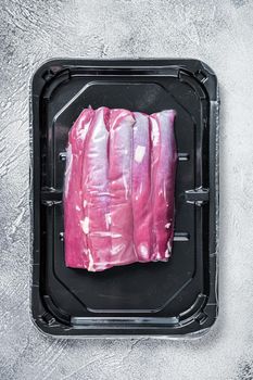 Raw lamb tenderloin in vacuum packaging. White background. Top view.