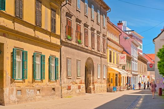 Maribor - June 2020, Slovenia: View of an old street with colorful apartment buildings and walking people (Slovenska Street)