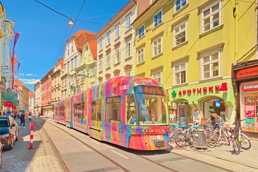 Graz - June 2020, Austria: A modern tram with colorful advertisements is going along one of the central streets of Graz