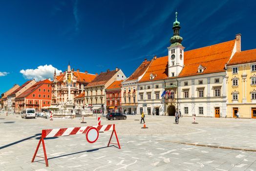  Maribor - June 2020, Slovenia: View of the main square of Maribor, Town Hall, old historical buildings, walking people, and a stop barrier