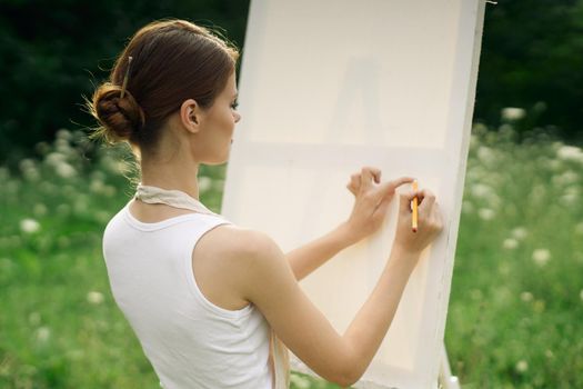 woman artist in aprons in nature draws a picture art. High quality photo