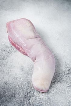 Raw beef tongue on butcher table. White background. Top view.