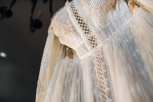 Vintage Wedding dress hanging on a wooden hanger.