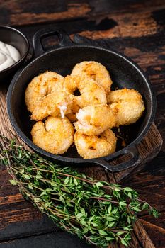 Fried Breaded Shrimps Prawns in a pan. Dark wooden background. Top view.