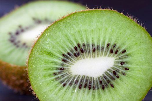 cut into half a ripe green kiwi fruit, closeup