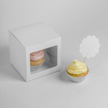 high angle two cupcakes with packaging box