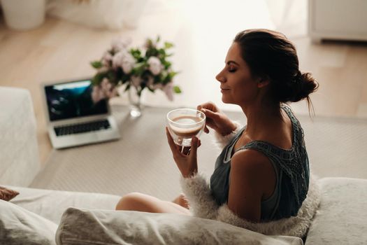 relaxed girl at home drinking coffee.Inner peace.The girl is sitting comfortably on the sofa and drinking coffee.