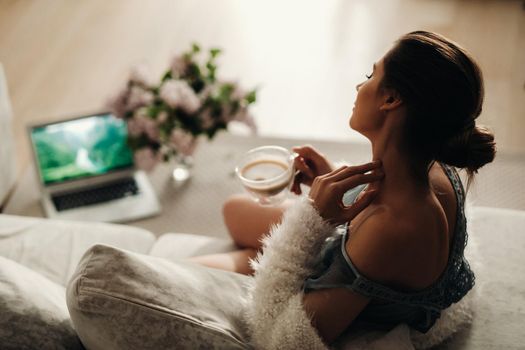 relaxed girl at home drinking coffee.Inner peace.The girl is sitting comfortably on the sofa and drinking coffee.