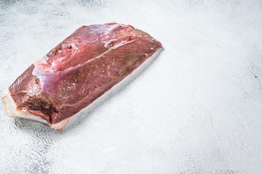 Raw duck breast fillet on a kitchen table. White background. Top view. Copy space.