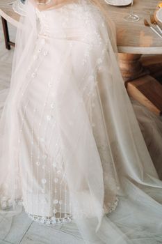 A luxurious bride in a wedding dress in the morning in her interior.