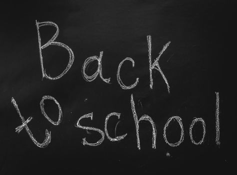 Inscription back to school in chalk on black chalkboard