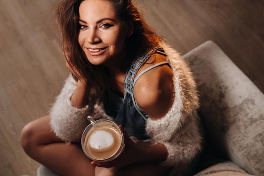 relaxed girl at home drinking coffee.Inner peace.The girl is sitting comfortably on the sofa and drinking coffee.