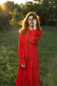 woman in red dress posing nature sun fun. High quality photo