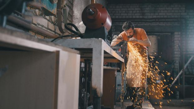 Blacksmith in forge - sharpening iron tools with sparkles - metal workshop, slider shot