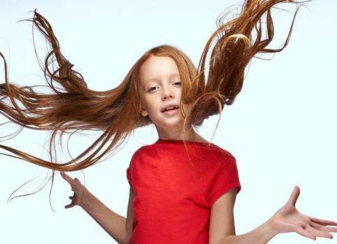 girl with red hair posing red t-shirt childhood. High quality photo