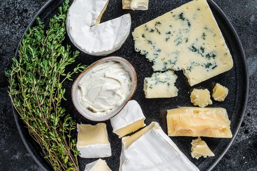 French Cheese plate. Camembert, Brie, Gorgonzola and blue cream cheese. Black background. Top view.