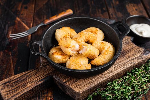 Fried Breaded Shrimps Prawns in a pan. Dark wooden background. Top view.