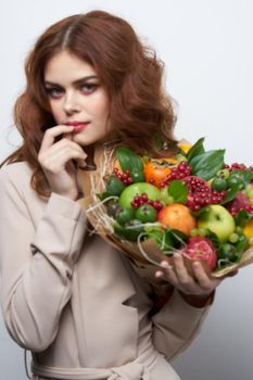 pretty woman smile posing fresh fruits bouquet emotions light background. High quality photo