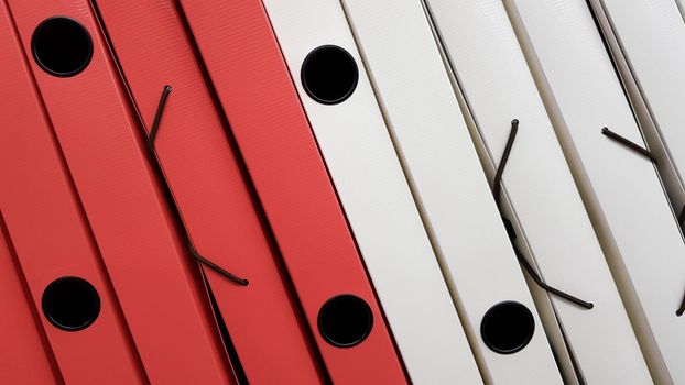 Various office folders on a supermarket shelf. Plastic and paper folders with documents are on the shelf of the cabinet