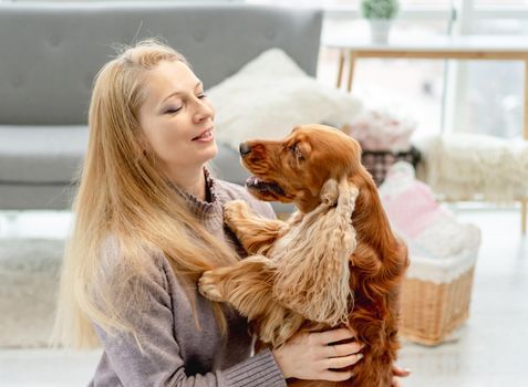 English cocker spaniel dog with loving woman owner sitting on floor at home
