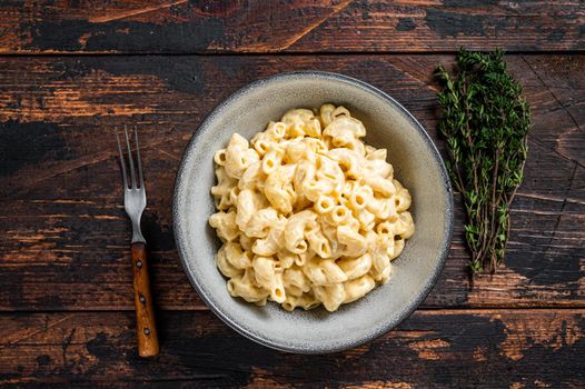 American dish Mac and cheese macaroni pasta with Cheddar. Dark wooden background. Top view.