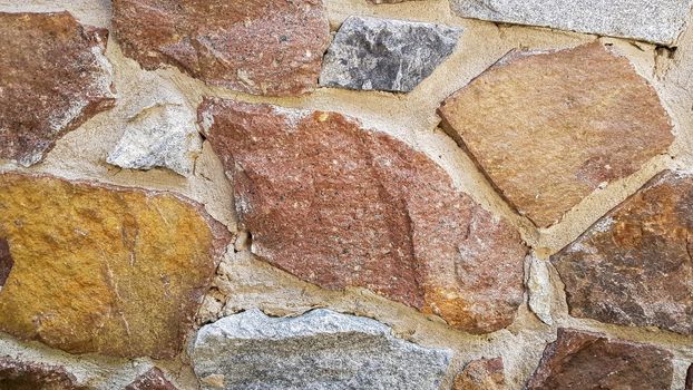 Gray stone wall background. The texture of the stone. Old castle wall background. Stone wall as a background or texture. Part of the wall, for background or texture