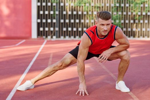 athletic man doing exercises outdoors sports field exercise. High quality photo