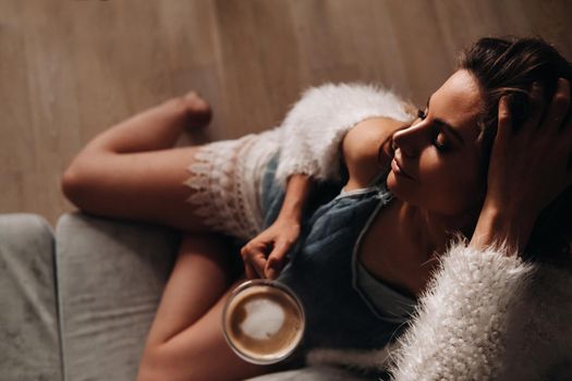 relaxed girl at home drinking coffee.Inner peace.The girl is sitting comfortably on the sofa and drinking coffee.