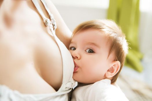 Mother breastfeeding her newborn baby. Milk from mom s breast is a natural medicine for children.