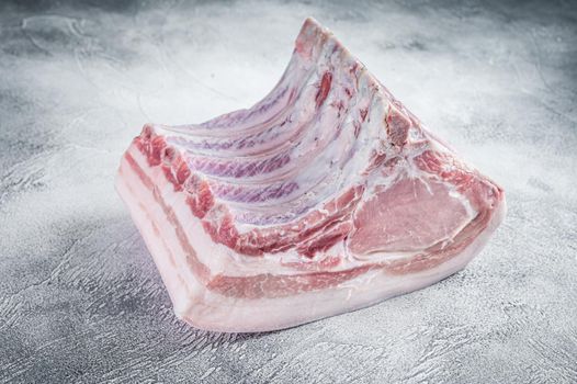 Raw whole rack of pork loin with ribs on kitchen table. White background. Top view.