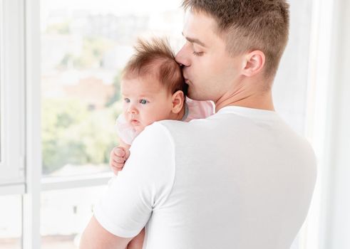 Father kissing infant sweet daughter