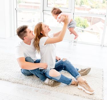 Parents holding up baby, view from above