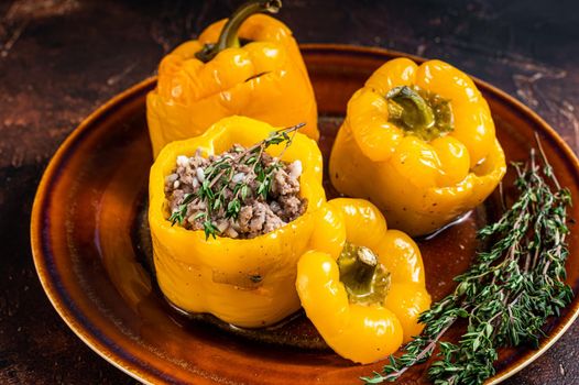 Baked Sweet bell pepper stuffed with beef meat, rice and vegetables. Dark background. Top view.