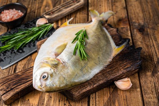 Raw fish Sunfish or pompano on a wooden board. wooden background. Top view.