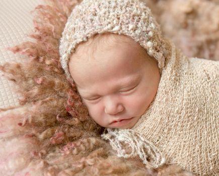 cute sleeping newborn baby in hat on fluffy blanket, closeup