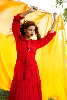 festively outdoors yellow cloth on the background of posing red dress. High quality photo