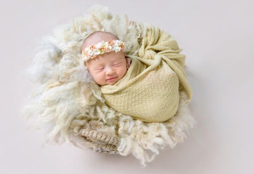 Lovely smile of a tiny little girl sleeping, wrapped up with a warm blanket
