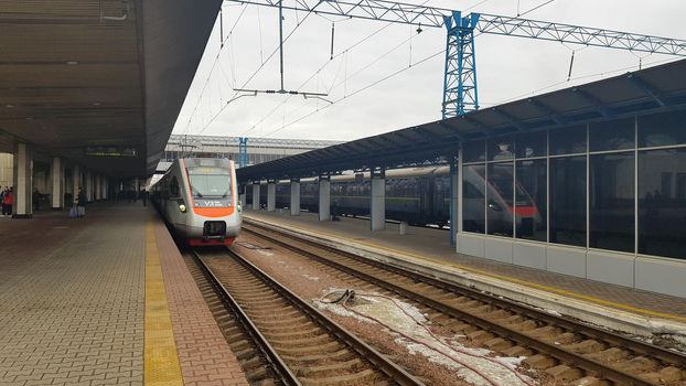 The high-speed passenger electric train Hyundai Rotem Tarpan HRCS2 Intercity stands on the platform of the central railway station in Kiev. Ukrainian railways. Ukraine, Kiev - June 09, 2021