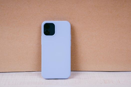 Smartphone in a blue silicone case. Silicone case to protect the back cover of the smartphone.