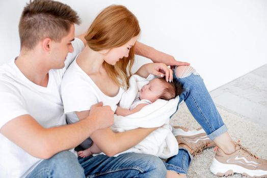 Father, mother and sleeping baby girl at home